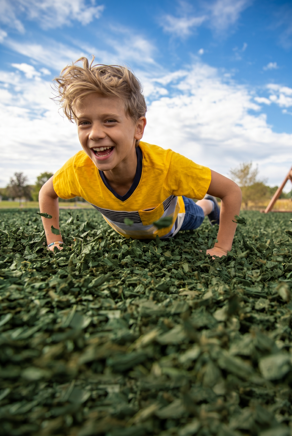 Boy having fun in rubber mulch in green color